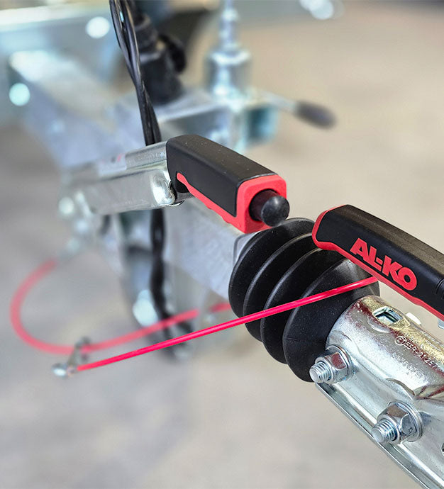 TREILER Kupplung, Nahaufnahme der Al-Ko Auflaufbremse und des Bremshebels.