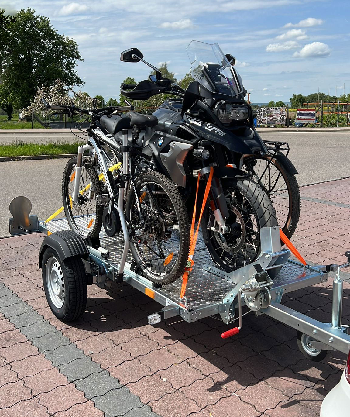 TREILER500 mit einer BMW GS und zwei E-Bikes auf einem Parkplatz